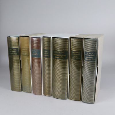several books are lined up in a row on a white surface
