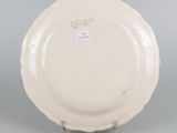 underside view of a white plate on a stand on a gray surface