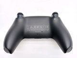 a close up of a black controller on a white surface