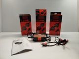 trois boîtes de piles et un chargeur posés sur une table
