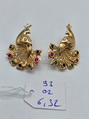 une paire de boucles d'oreilles en or en forme de paon, ornées de pierres multicolores