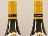 two bottles of wine are sitting on a white surface