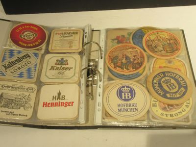 un livre ouvert sur lequel sont posés plusieurs sous-verres à bière