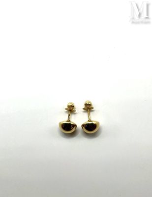 a pair of black and gold earrings on a white surface