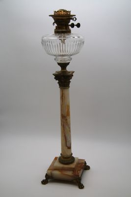 une lampe à l'ancienne surmontée d'un abat-jour en verre