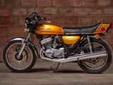 a yellow motorcycle parked in front of a brick wall