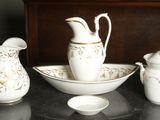 trois vases blancs et dorés et un bol posés sur une table