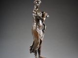 an antique bronze statue of a woman holding a vase