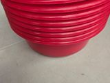 plusieurs bols en plastique rouge empilés les uns sur les autres sur un plan de travail