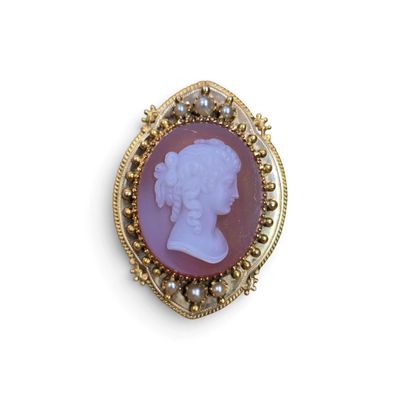 une image représentant une broche violette et dorée avec le profil d'une femme