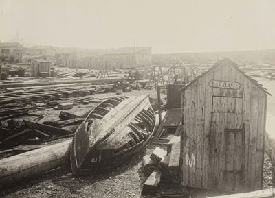a boat that is sitting on the ground next to a shack