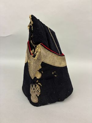 un vieux chapeau noir orné d'une bordure dorée et d'un ruban doré