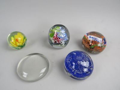 quatre billes de verre sont posées sur une surface blanche