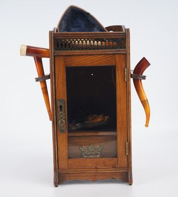 une petite armoire en bois sur laquelle est posé un chapeau