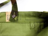 a close up of a green bag with a button on it