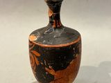 a black and orange vase sitting on a white surface