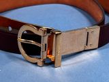 a brown belt with a gold buckle on a blue surface