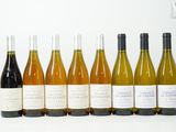six bouteilles de vin sont alignées sur une table