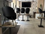 tables and chairs in a room with a television on the wall