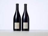 two bottles of wine sitting on top of a table next to each other