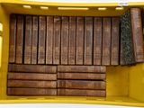 de nombreux livres anciens dans une boîte jaune posée sur la table