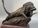 statue en bronze représentant un lion attaquant un autre lion, posée sur un socle en marbre
