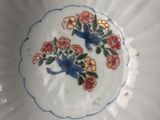 a white bowl with a blue and red flower design on it