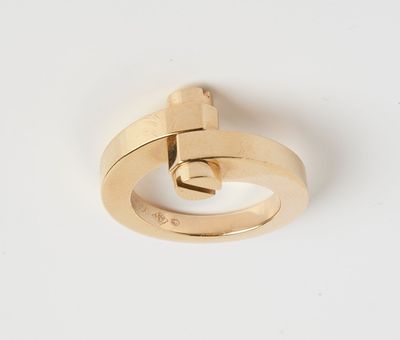 gros plan d'une bague en or sur une surface blanche
