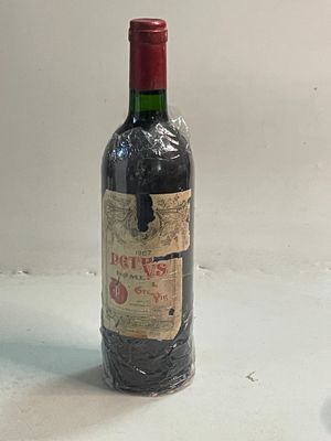 une bouteille de vin posée sur une table à côté d'un verre de vin