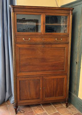 une grande armoire en bois surmontée d'une porte vitrée
