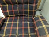 plaid chair in a room with a chair cushion on the back