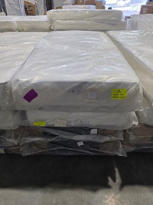 a lot of mattresses that are on the floor in the warehouse