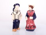 two figurines of a man and a woman standing next to each other