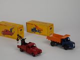 three toy trucks sitting next to each other on a white surface