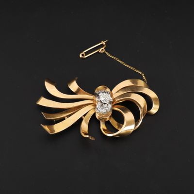 une broche en or et diamants avec une chaîne