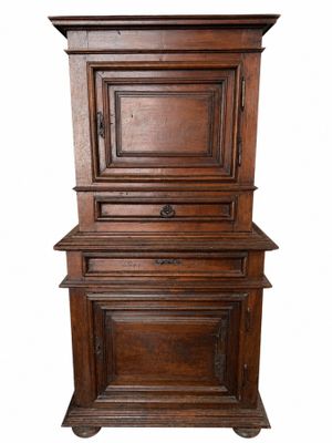 une vieille armoire en bois comportant deux tiroirs et une porte sur le dessus