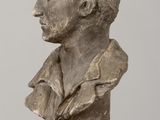 statue of a bust of a man sitting on a wooden table