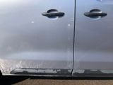 a silver car that has been dented and is parked in a parking lot