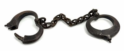pair of old iron handcuffs with chains on a white background