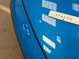 a close up of a blue car with a sticker on it ' s hood
