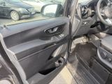 the interior of a car with the door open and the driver ' s seat down