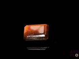 un gros plan d'un morceau de quartz orange sur une surface noire