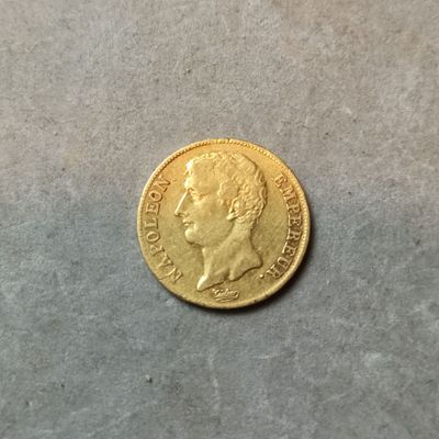 gros plan d'une pièce d'or sur une surface grise