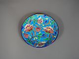 une assiette bleue ornée de fleurs, posée sur un mur