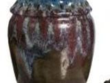 un vase marron et bleu à côté d'un chat marron et blanc