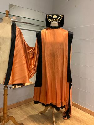 un mannequin dans une pièce où sont exposés deux costumes