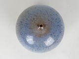 a blue vase with a hole in it on a white surface