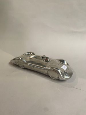 une image représentant un objet en forme de voiture argentée posé sur une surface blanche