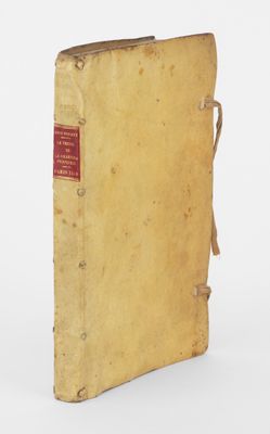 un vieux livre portant une étiquette rouge, posé sur une surface blanche