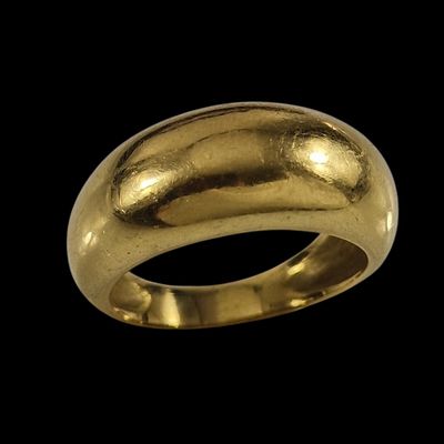 gros plan d'une bague en or sur fond noir